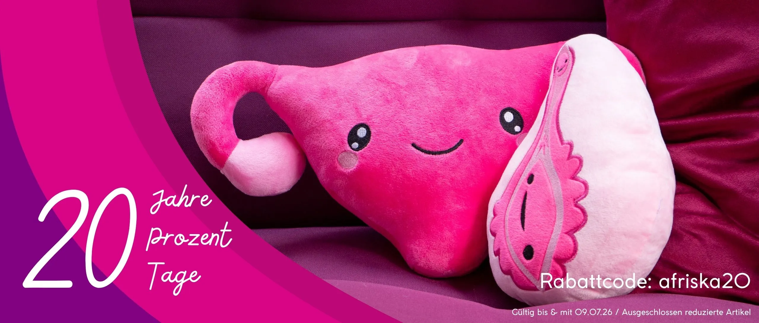 Pinke Plüsch-Gebärmutter und Vulva auf einem fuchsiafarbenen Kissen zur 20-Jahre-Aktion von Afriska.