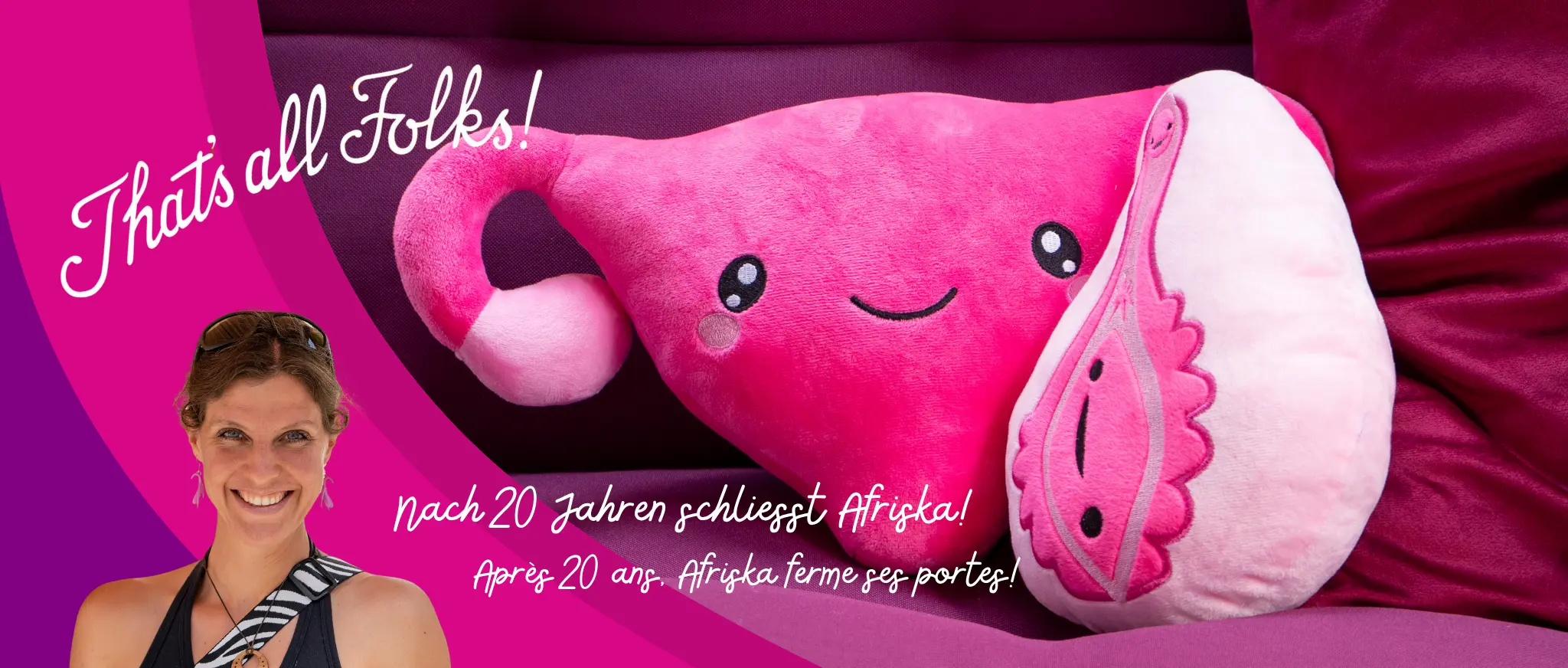 Franziska d’Afriska sourit au soleil devant un fond fuchsia avec un utérus et une vulve en peluche roses.
